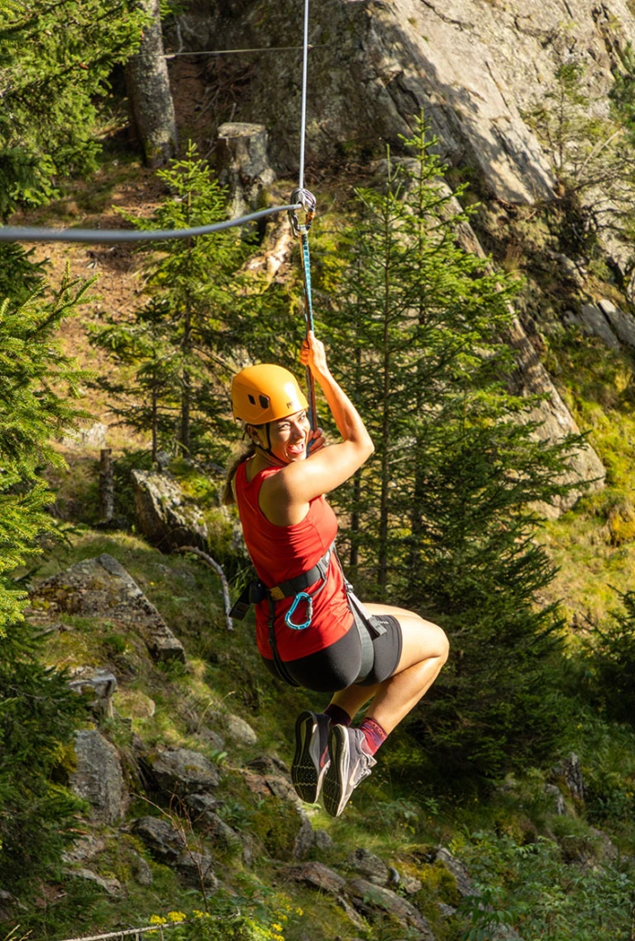 Kletterpark - Klippitztörl Frau hängt an Zipline - Abenteuerurlaub mit der Familie in Kärnten